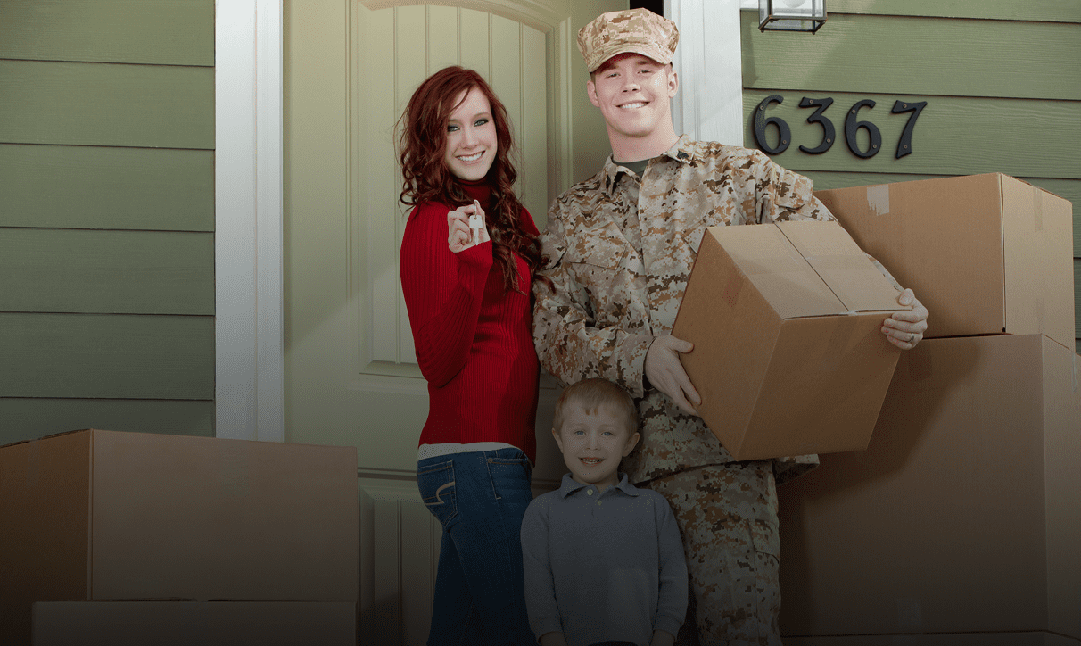 A soldier returns home, greeted by his smiling family at the door.