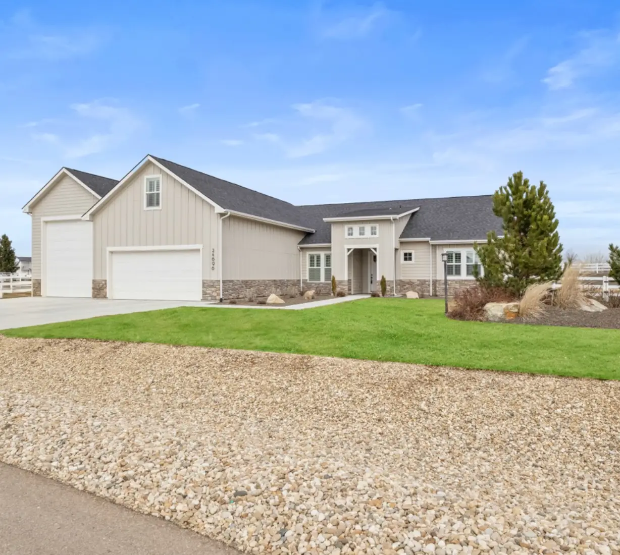 Modern single-story house with a spacious driveway and well-maintained lawn.