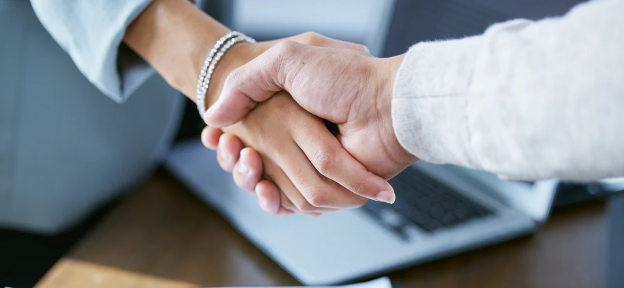 Handshake over a laptop